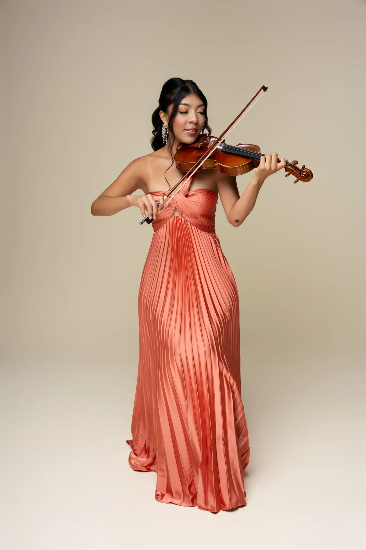Full-length portrait of Bets performing in a coral gown